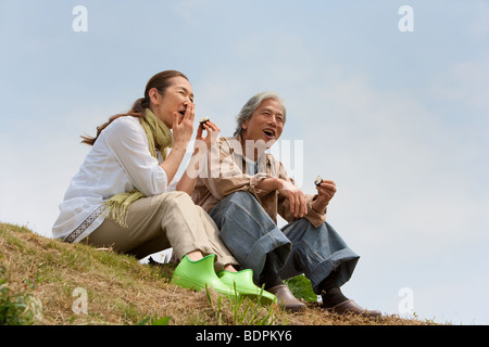 Senior couple sitting on field Stock Photo