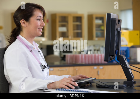 Female lab technician working on a computer Stock Photo