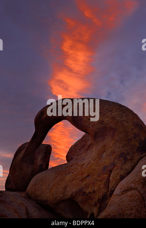 A wave cloud catches dawn light above the Whitney Arch in the Alabama Hills near Lone Pine, California, USA.