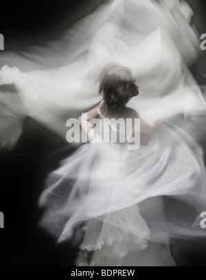A young woman dancing with a white dress Stock Photo