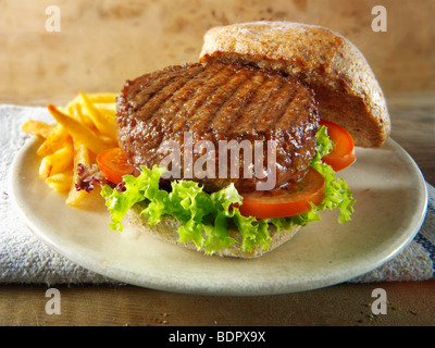 Beef burger in a wholemeal bun with salad and french fries Stock Photo