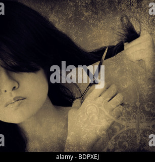 A young asian woman cutting her own hair Stock Photo