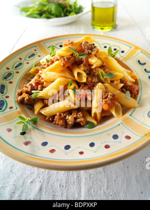 Fresh cooked pene and bolognese ragout served on a plate in a table setting. Serving suggestion Stock Photo