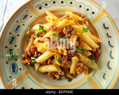 Fresh cooked pene and bolognese ragout served on a plate in a table setting. Serving suggestion Stock Photo