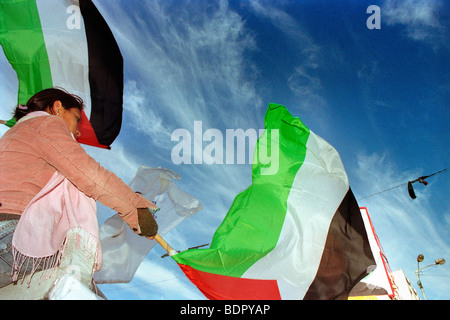 Woman waving a Palestinian flag during a protest in Al-Manara Square, Ramallah, Palestine