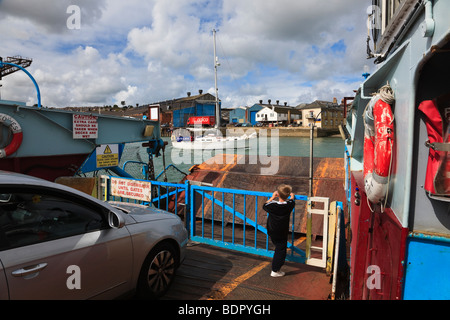 A small boy looks as a yacht passes the waiting Chain ferry that connects East and West Cowes Isle of Wight, UK Stock Photo