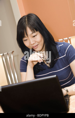 Beautiful Asian woman working on a laptop computer Stock Photo