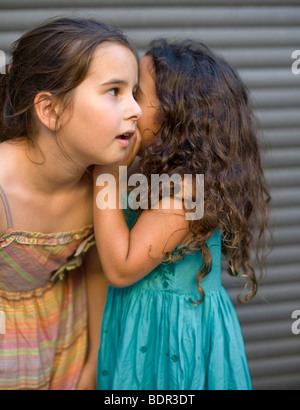 two girls telling a secret