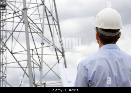 Engineer looking at construction side with plan in his hand Stock Photo