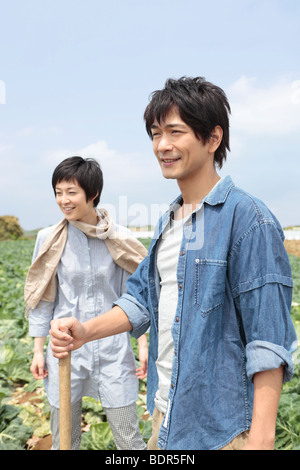 Young couple standing in cabbage field Stock Photo