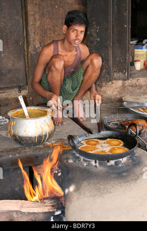 Young Indian Man Frying Samosas Over An Open Fire In Puri, Orissa Stock Photo