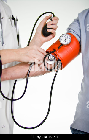 A female doctor using a blood-pressure gauge Stock Photo