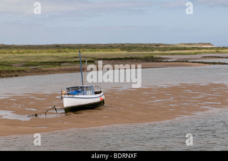 Anchored boat stuck in tidal mud flat at low tide in Morro Bay ...