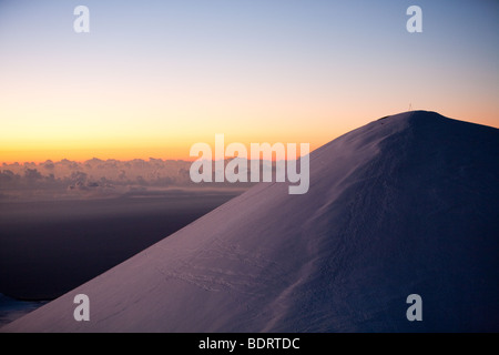 The snow-covered summit cone of Mauna Kea, Hawaii, seen at dawn. Stock Photo