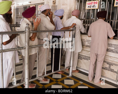 Sikh men buying food to provide a meal offering at the Golden Temple (Sri Harmandir Sahib) Amritsar. India. Stock Photo