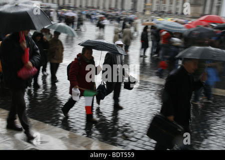 tourists in heavy rain in st peters square rome Stock Photo