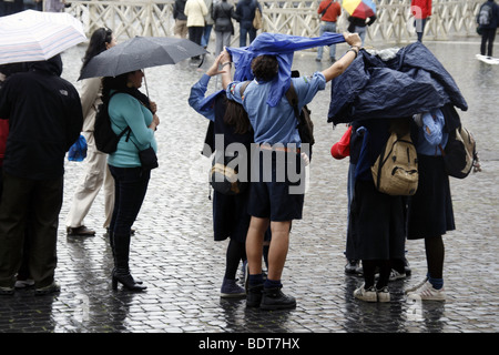 scout group tourists in a queue in heavy rain in vatican, rome Stock Photo