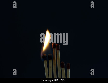 bright flame as two matches are set on fire whilst four matches stay unlit Stock Photo