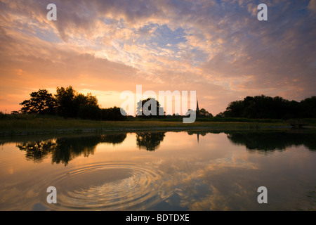 Salisbury Cathedral reflected in a pond at dawn, Salisbury, Wiltshire, England. Summer (June) 2009 Stock Photo