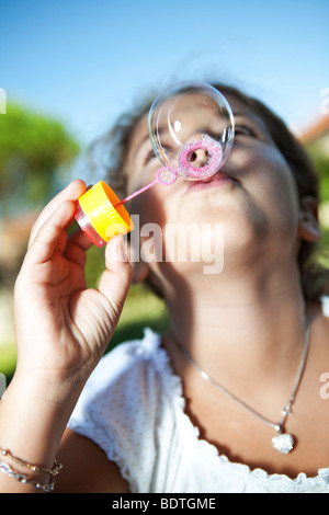 Pretty girl blowing soap bubbles Stock Photo