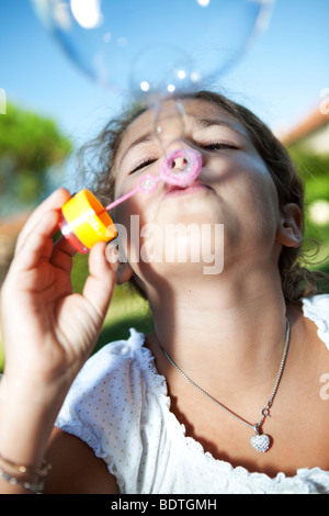Pretty girl blowing soap bubbles Stock Photo