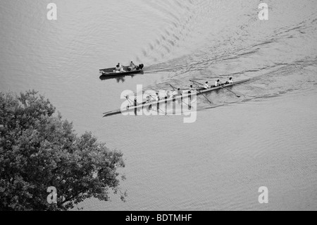 Crew rowers practice rowing in an 8 / eight person scull on the Schuylkill river outside of Philadelphia PA near Boathouse Row Stock Photo