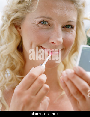 Woman using lip gloss Stock Photo