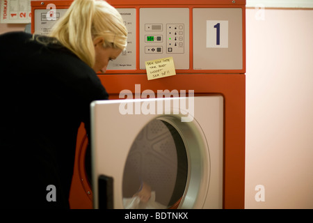 Blond woman in a laundry room Stock Photo