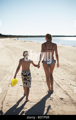 Mother and son walking on the beach Gotland