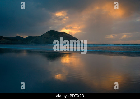 luminous landscape, amazing light display sunbeams beach sunset, Wharariki Beach, Golden Bay, New Zealand,  South Island, Nelson Stock Photo
