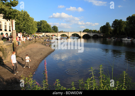 Boys throwing stones into the river Thames Richmond, Surrey UK Stock Photo