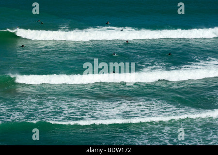 a bunch of surfers waiting for the perfect wave to ride on, Maori Bay, Muriwai Regional Park, North Island, New Zealand Stock Photo
