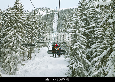 Skiers on a chairlift, Meribel ski resort in the Three Valleys, Les Trois Vallees, Savoie, French Alps, France Stock Photo