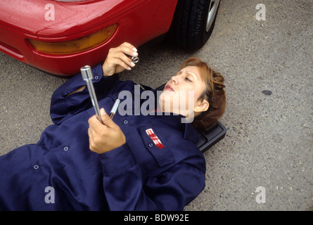 Female latina auto tech repairs auto work overall male work  'man's job' Stock Photo