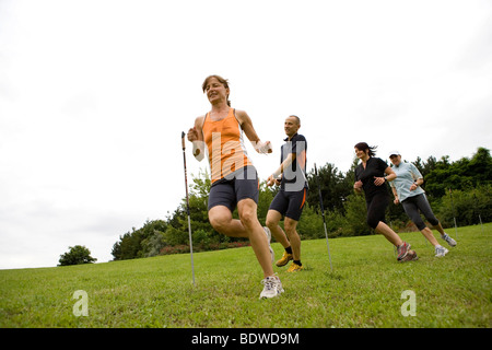 A personal trainer and three women on the obstacle course in a park Stock Photo