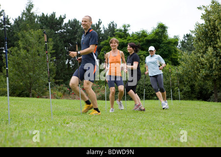 A personal trainer and three women on the obstacle course in a park Stock Photo