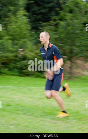 An athlete running in a meadow Stock Photo