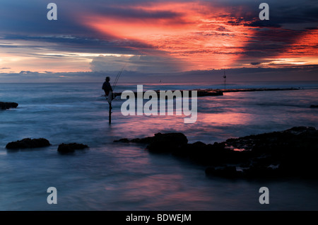 Stilt fishermen at the sunset in Weligama beach in Sri Lanka Stock Photo