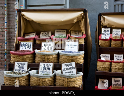 Straw baskets full of colourful herbs, spices and teas at a market stall in near the Cathedral in Granada in Spain Stock Photo