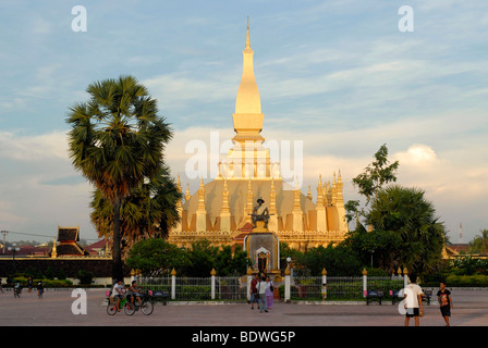 The majestic golden stupa with playing children and young people, That Luang, national symbol of Laos, Vientiane, Laos, Asia Stock Photo