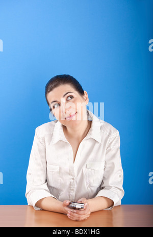 Young businesswoman sitting in office and thinking in something Stock Photo