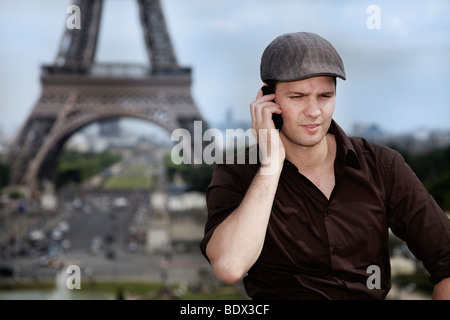 Young man on his mobile phone, the Eiffel Tower, Paris, France, Europe Stock Photo