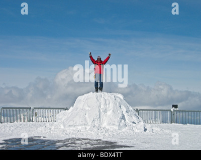 Man enjoys 'top of the world' view from outside viewing deck of  Shilthorn revolving restaurant in the Swiss Alps of Grinelwald Stock Photo