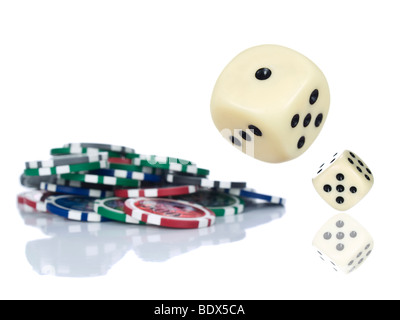 Two dices rolling beside some gambling chips. Isolated on white. Stock Photo