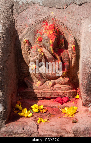 Kathmandu, Nepal. Stone Sculpture of the God Ganesh, with Flowers and Sindur Offerings. Stock Photo