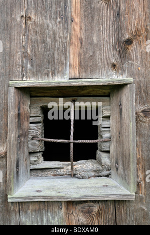 Window with iron bars in a wooden wall Stock Photo