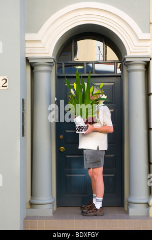 Courier ringing doorbell to deliver plants in Fremantle Western Australia Stock Photo