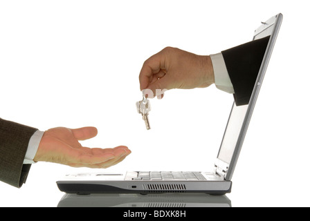 Business man giving a home key to another business man through a computer monitor, symbolic image for real estate market on the Stock Photo