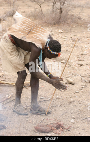 Africa, Tanzania, Lake Eyasi, Hadza men light camp fire by rubbing two sticks together Stock Photo