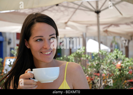 Beautiful young woman enjoying a coffee Stock Photo